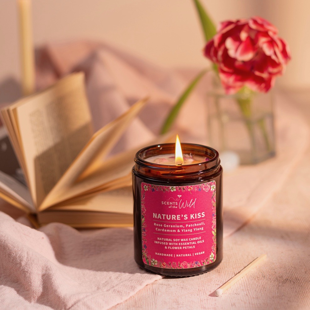 Lit Nature's Kiss natural botanical candle jar with open book and pink flower